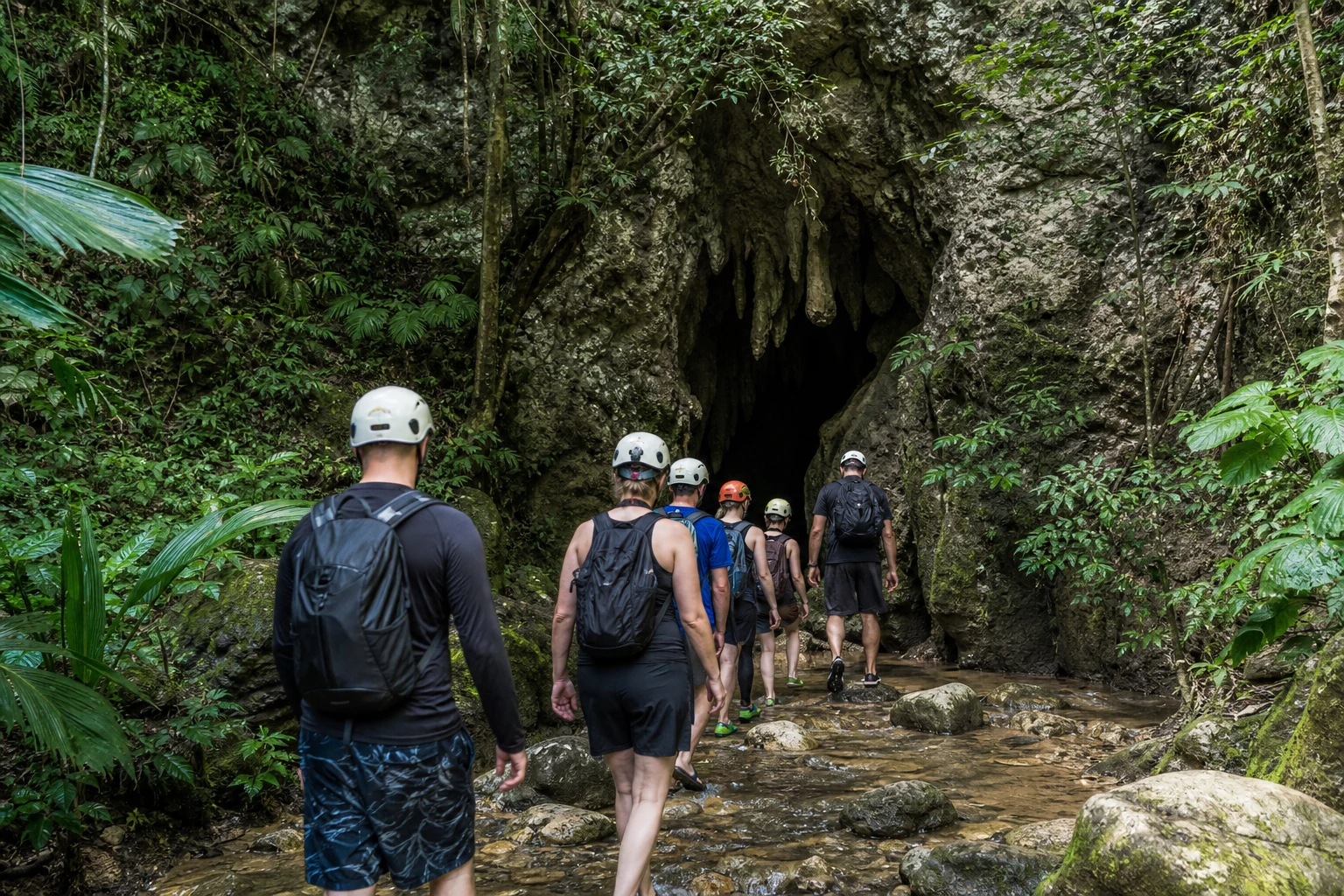 Travelers approaching Actun Tunichil Muknal Cave through the Belize jungle