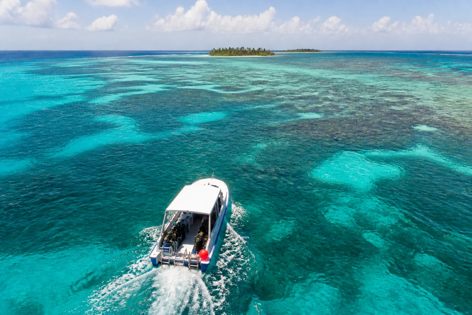 Dive boat traveling across Belize Caribbean waters toward the reef