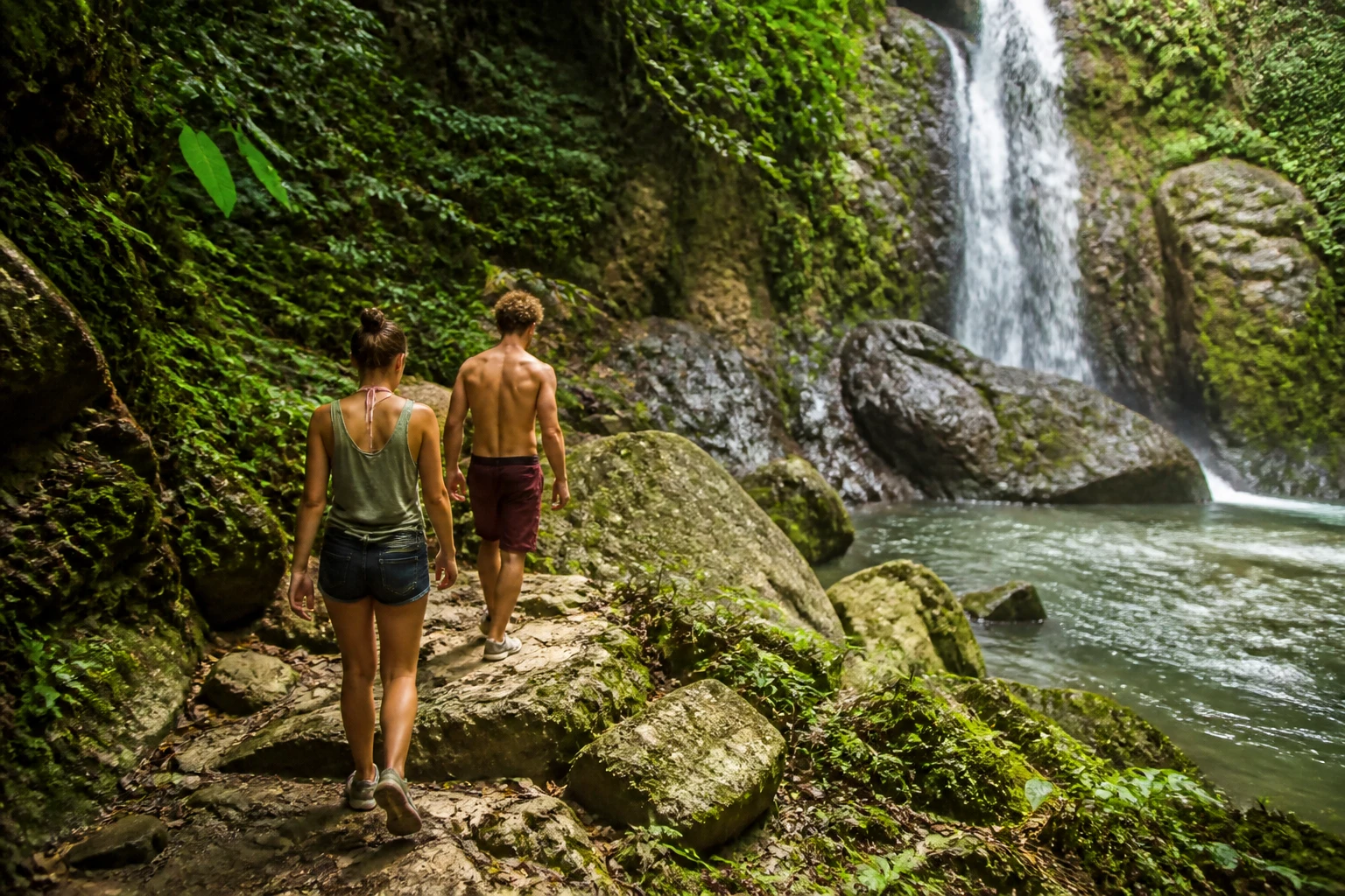 Couple exploring a rainforest waterfall in Belize