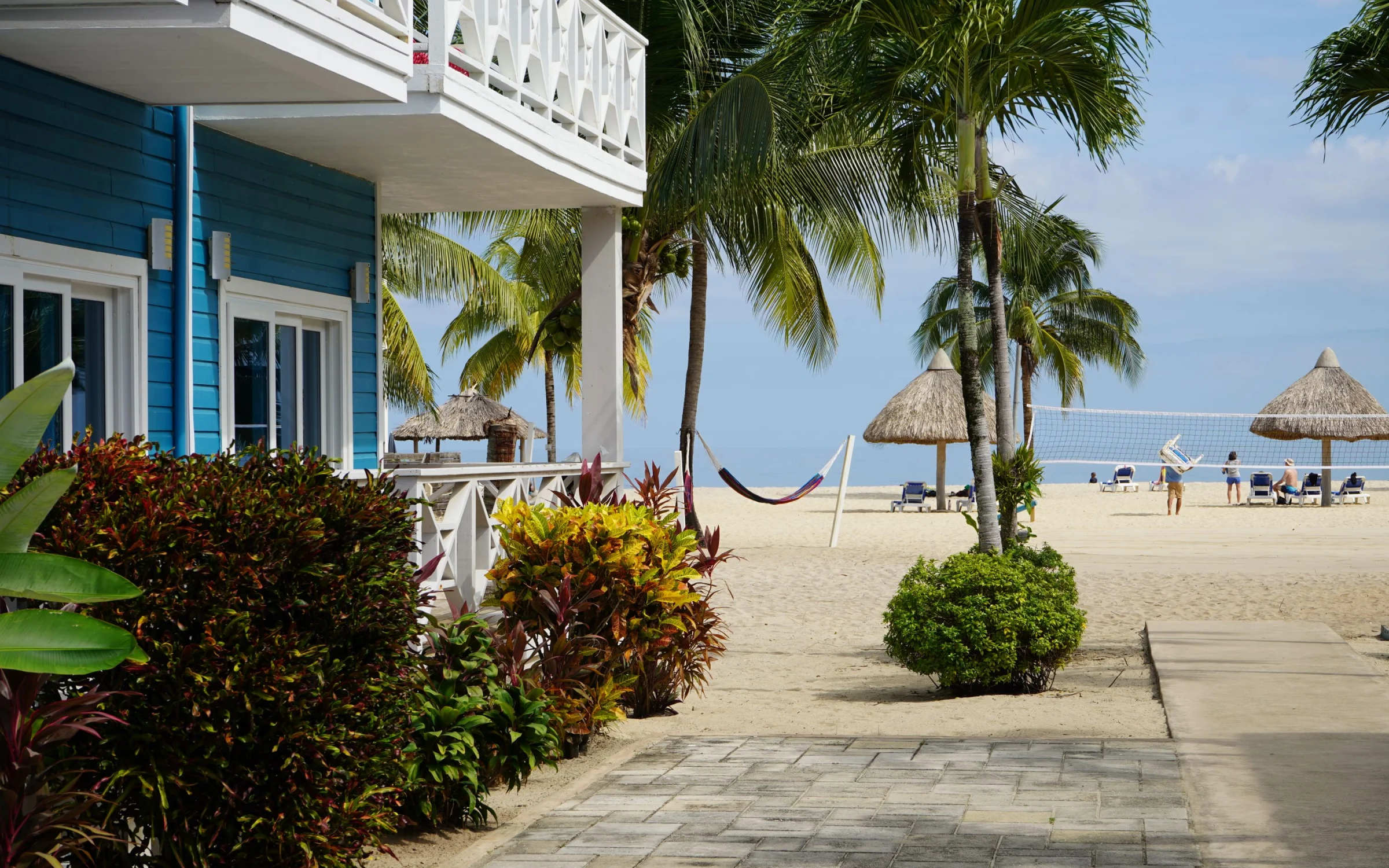Palm-lined beach at Placencia with wooden pier
