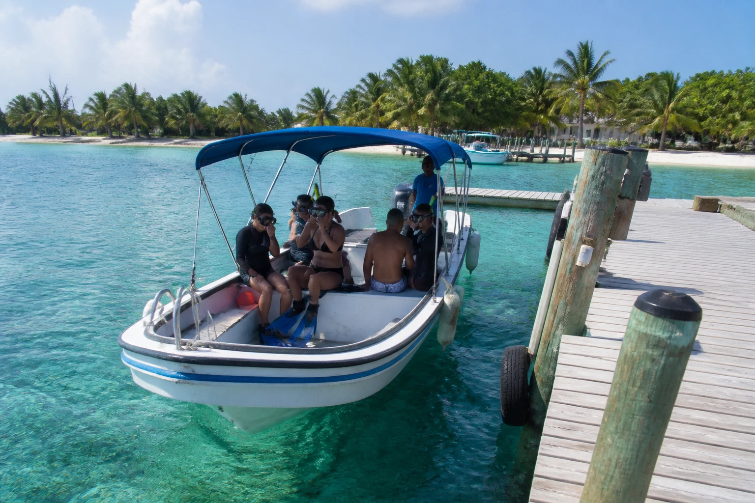 A snorkeling boat leaving an island dock in Belize