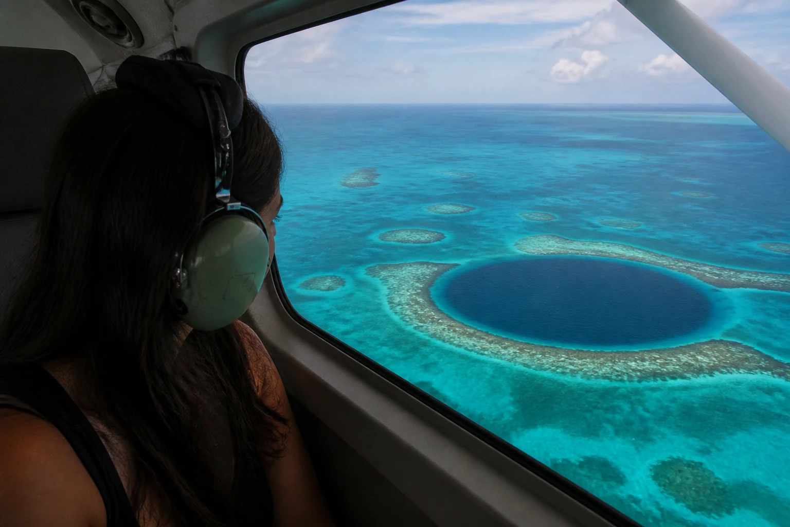 Passenger viewing the Great Blue Hole during a scenic flight over Belize