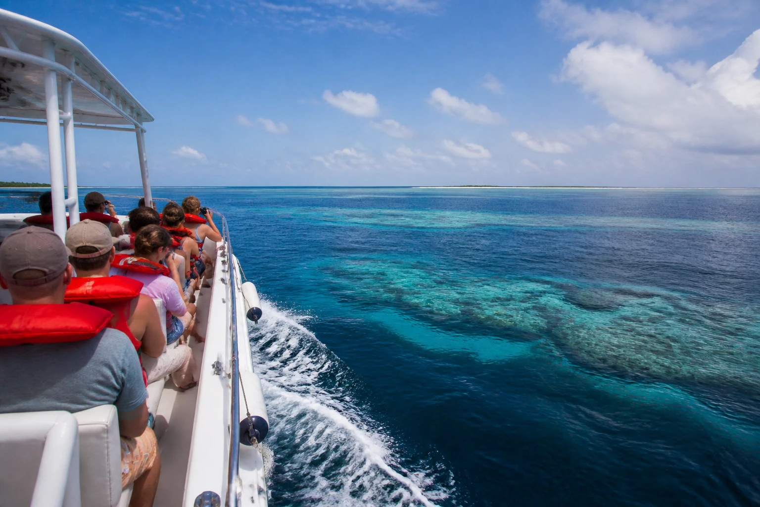 Marine excursion boat traveling toward an offshore Belize reef