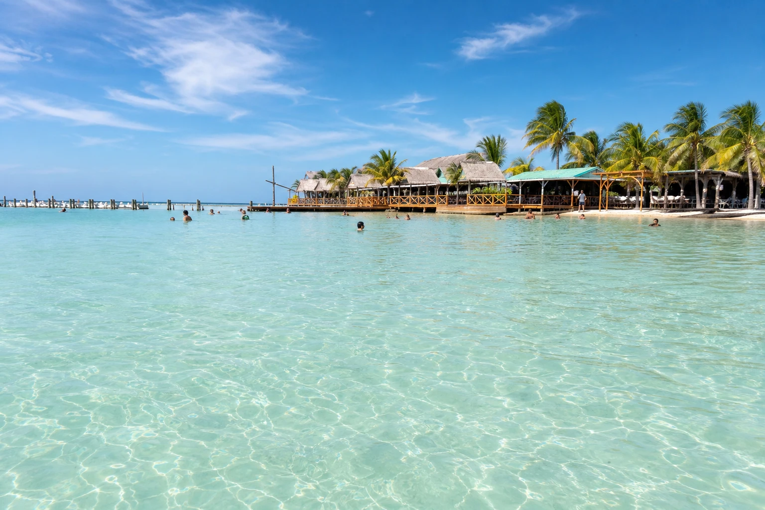 Shallow lagoon water and beach clubs at Secret Beach on Ambergris Caye